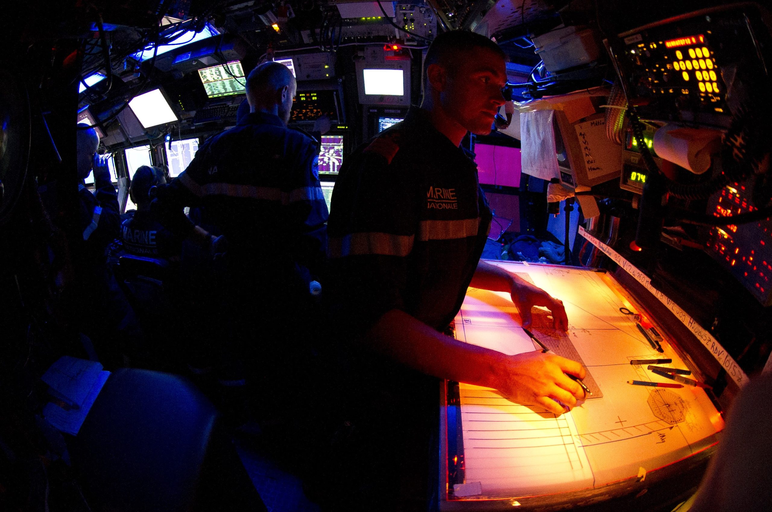 Sous-marinier devant la table traçante à bord du SNA Saphir © Marine Nationale, V. MAUPILE